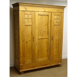  Early 20th century continental triple pine wardrobe, projecting cornice, three panelled doors, bun feet, W159cm, H199cm, D60cm   