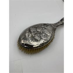 Victorian silver chamber stick, in the form of a shamrock with heart loop handle, hallmarked Stokes & Ireland Ltd, Birmingham 1892, Edwardian silver mounted handheld mirror, decorated in relief with a group of cherubs, with engraved initials, hallmarked Birmingham 1907, maker's mark indistinct and a similar silver mounted hairbrush, hallmarked Henry Matthews, Birmingham 1907, approximate weighable silver 1.67 ozt (51.8 grams)
