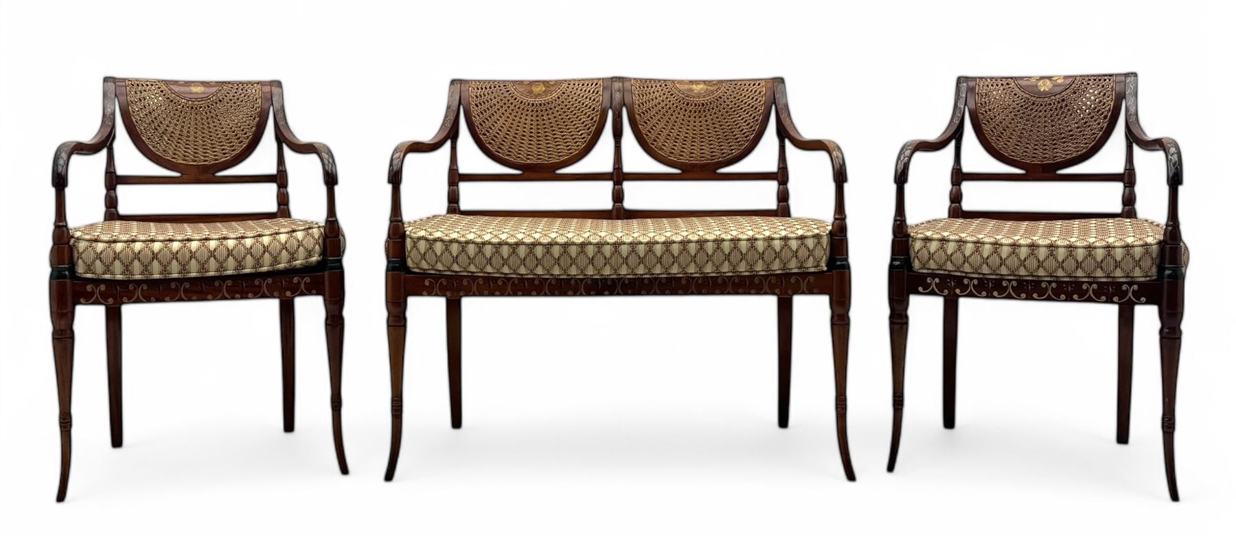 Edwardian Sheraton Revival inlaid mahogany parlour suite, comprising a two-seater settee and two matching armchairs, each with fan-shaped caned back, shaped crest rail with foliate inlay, scrolled open arms, upholstered seat with repeating geometric pattern, on turned and tapered front supports