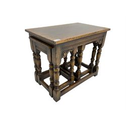 Traditional oak nest of three tables, on turned supports joined by plain stretchers, scroll carved brackets
