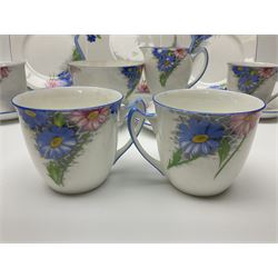 Shelley Strand shaped tea wares, decorated with blue and pink daisies upon a white ground, comprising four teacups, four saucers, three tea plates, milk jug, sugar bowl and cake plate, all with printed green mark beneath and painted pattern no 12216