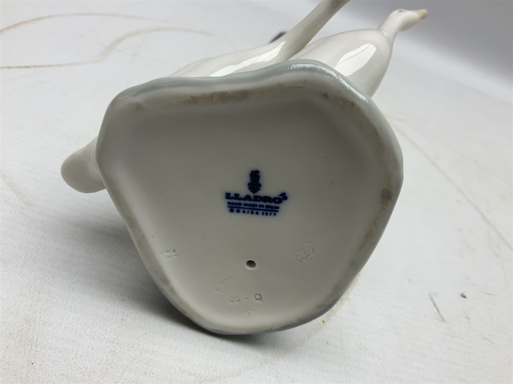 Seven Lladro figures, comprising Playful Puppy no 9135, Platero and Marcelino/Boy Hugging Donkey no 1181, Mini Seal Family no 5318, Attentive Polar Bear no 1207, Seated Polar Bear no1209, Eskimo Boy with Pet no 5238 and Girl with Geese no 1035, together with Nao goose