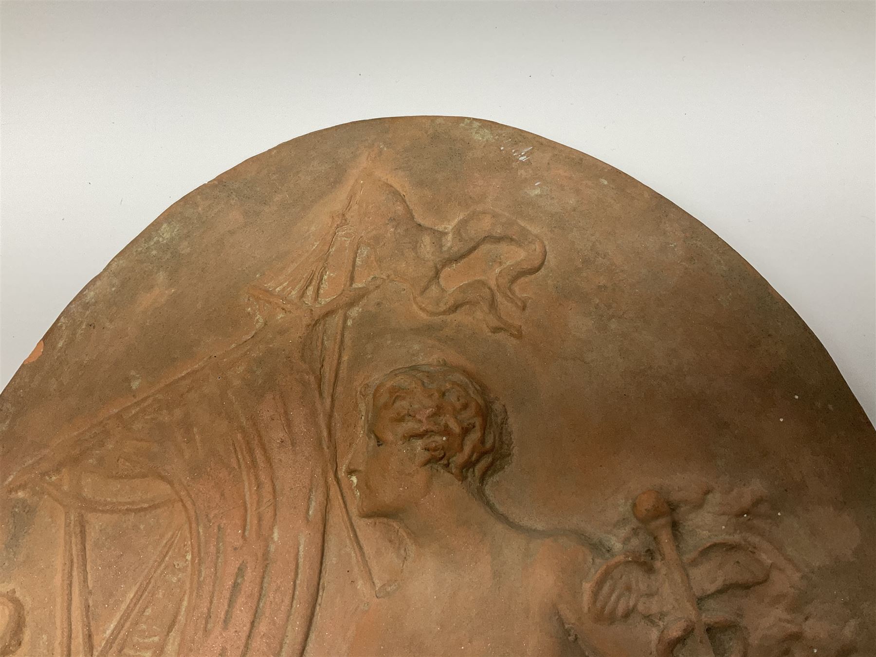 Pair of 19th century classical terracotta relief wall plaques depicting the goddess Hygeia and another goddess, seated holding an ewer, each of oval form, indistinctly signed, each stamped Ferreira verso, H42cm, W30cm