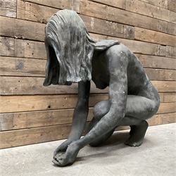 Composite garden statue of nude woman kneeling