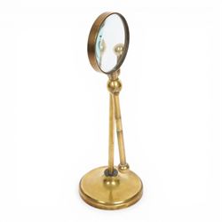 Early 20th century lacquered brass table top adjustable magnifying glass, with pivoting lens upon a circular weighted base, H26cm