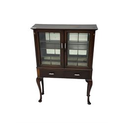 Early 20th century mahogany display cabinet, enclosed by two lead glazed doors, inlaid with Art Nouveau design stylised tulip in mother of pearl and boxwood, fitted with two drawers, on cabriole supports 