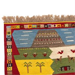 South West Persian Qashqai kilim, the field arranged with stepped polychrome panels depicting stylised camels, goats, cattle and birds, interspersed with trees and flowering stems, enclosed by a red border with multicoloured geometric devices