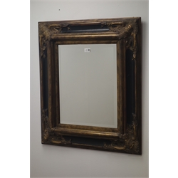  Gilt and black moulded cushion framed bevel edge mirror, W68cm, H79cm  