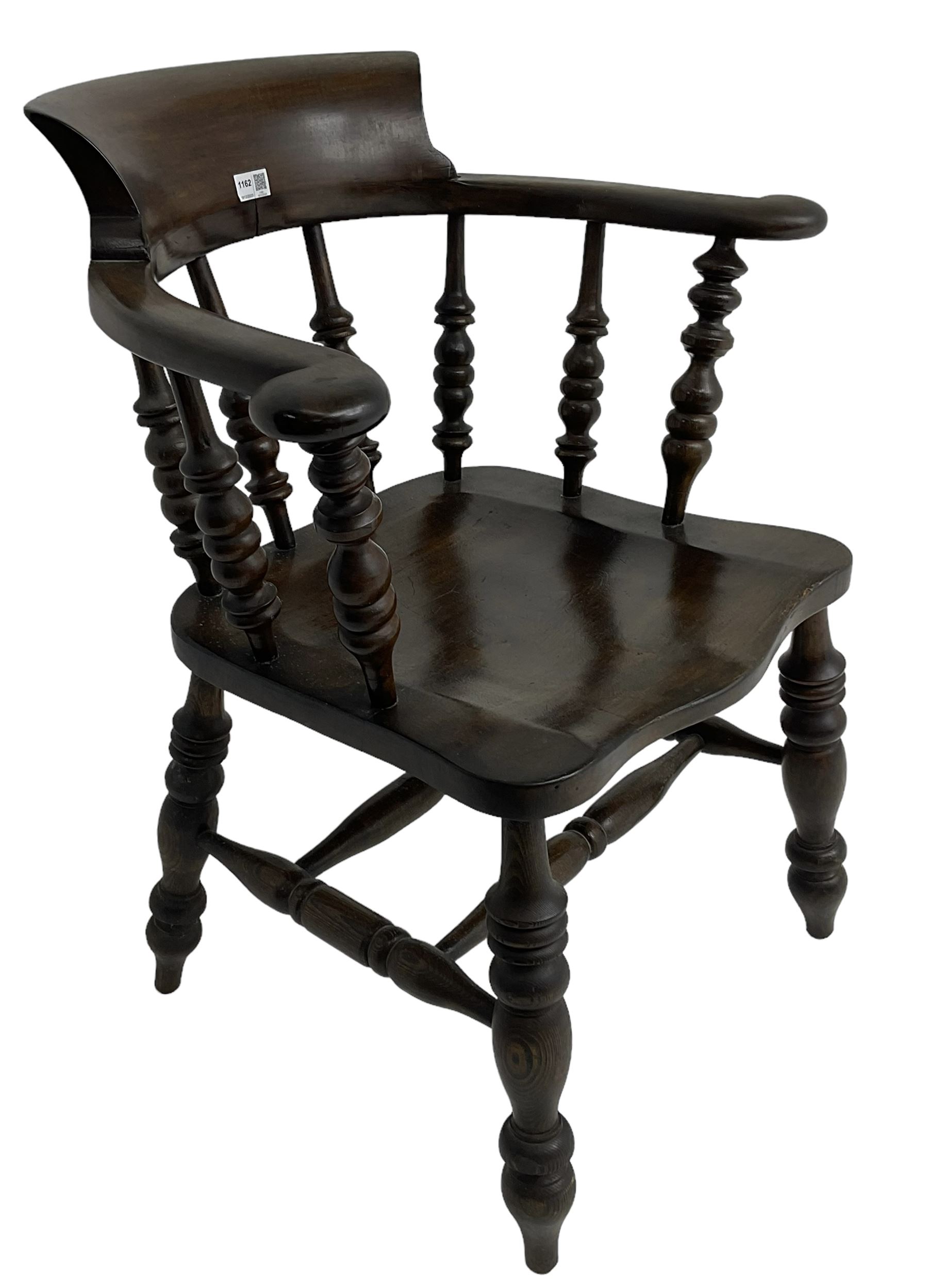 Early 20th century stained beech captains smokers bow chair, spindle tub shaped back over saddle seat, raised on turned supports united by double H-stretcher