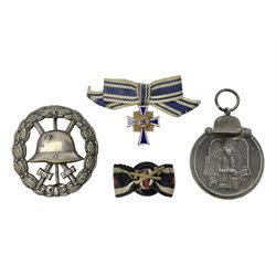 Four German awards - pre-WW2 two-position button hole ribbon for 1914 Iron Cross; WW1 wound badge open back cut-out version with silvered finish; miniature version Mother's Cross with ribbon bow; and The Eastern Medal, officially the Winter Battle in the East 1941–42 Medal (4)