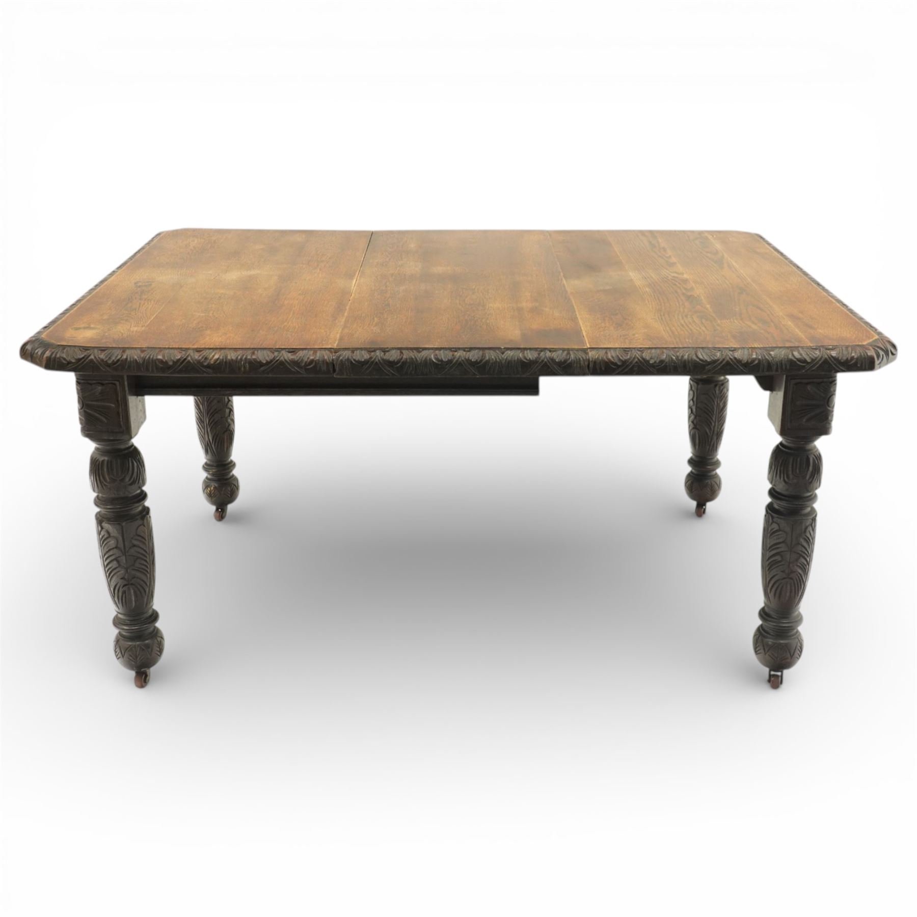 19th century heavily carved oak extending dining table, with winding mechanism and a gadrooned edge, over block and turned supports terminating in castors, extends to 147cm