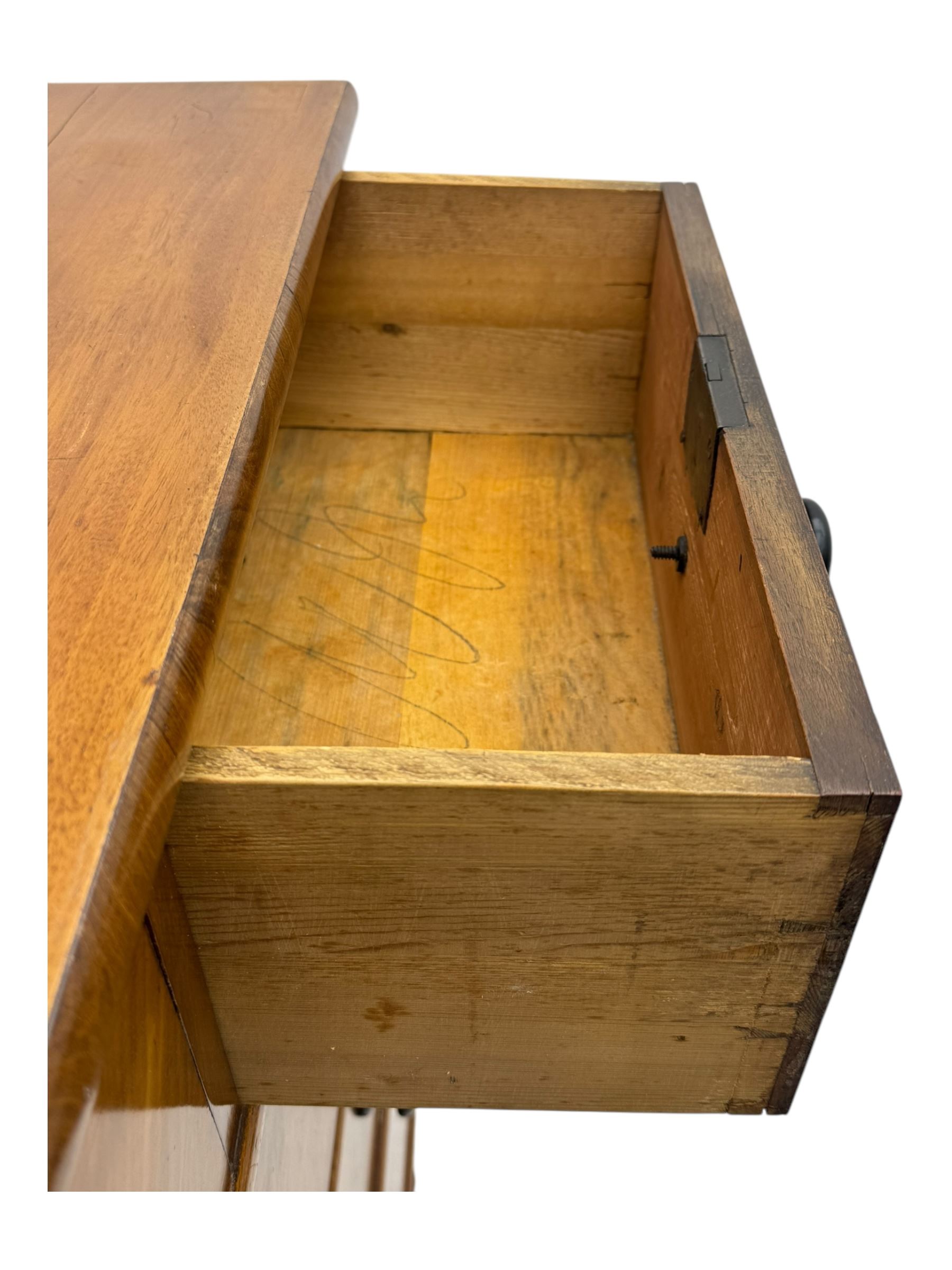 Late Victorian mahogany chest of drawers, with rectangular top over two short and three long graduated drawers, each fitted with ebonised turned knob handles and keyholes, raised on turned supports