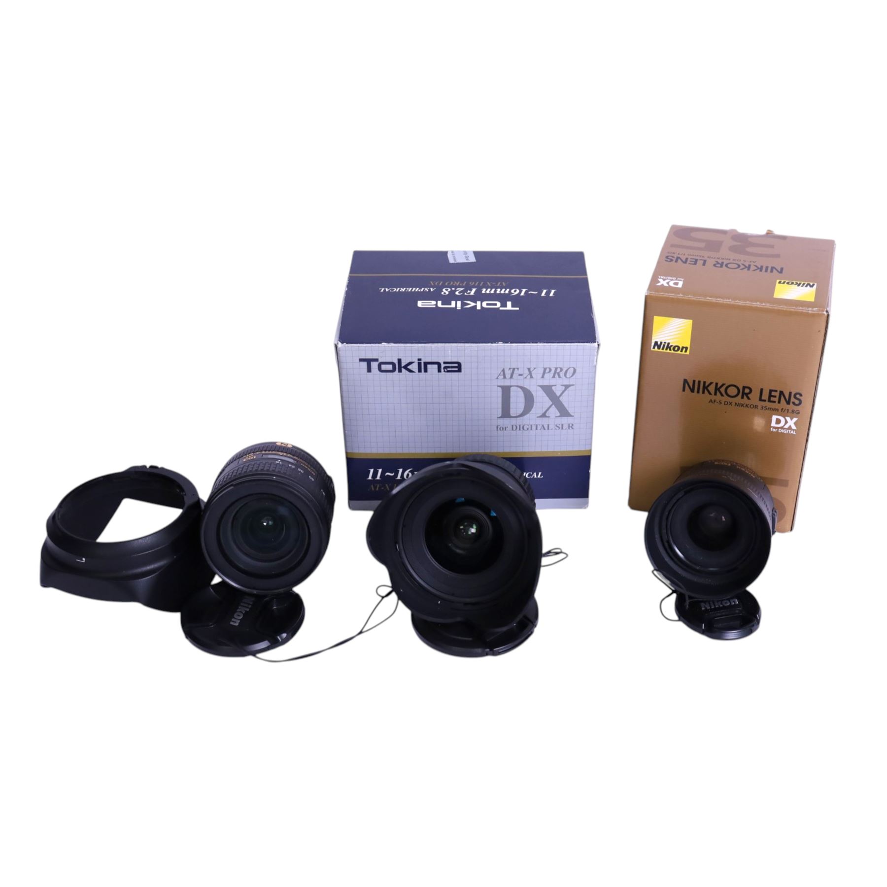 Three DSLR camera lenses, comprising Nikon Nikkor AF-S DX 35mm f/1.8G, boxed, Tokina AT-X Pro 11-16mm F28 Aspherical lens, boxed and Nikon Nikkor AF-S 16-80mm 1:2.8-4E ED lens and a 