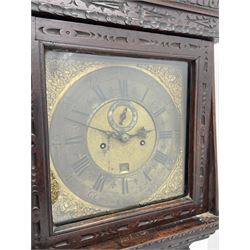 18th century oak longcase clock with later carving, the hood with projecting cornice over square glazed door, trunk door carved with tree of life, foliage carved base, on ogee bracket feet, brass dial with Roman chapter ring and subsidiary seconds and calendar aperture, ornate mask cast spandrels, twin train driven movement striking on bell 