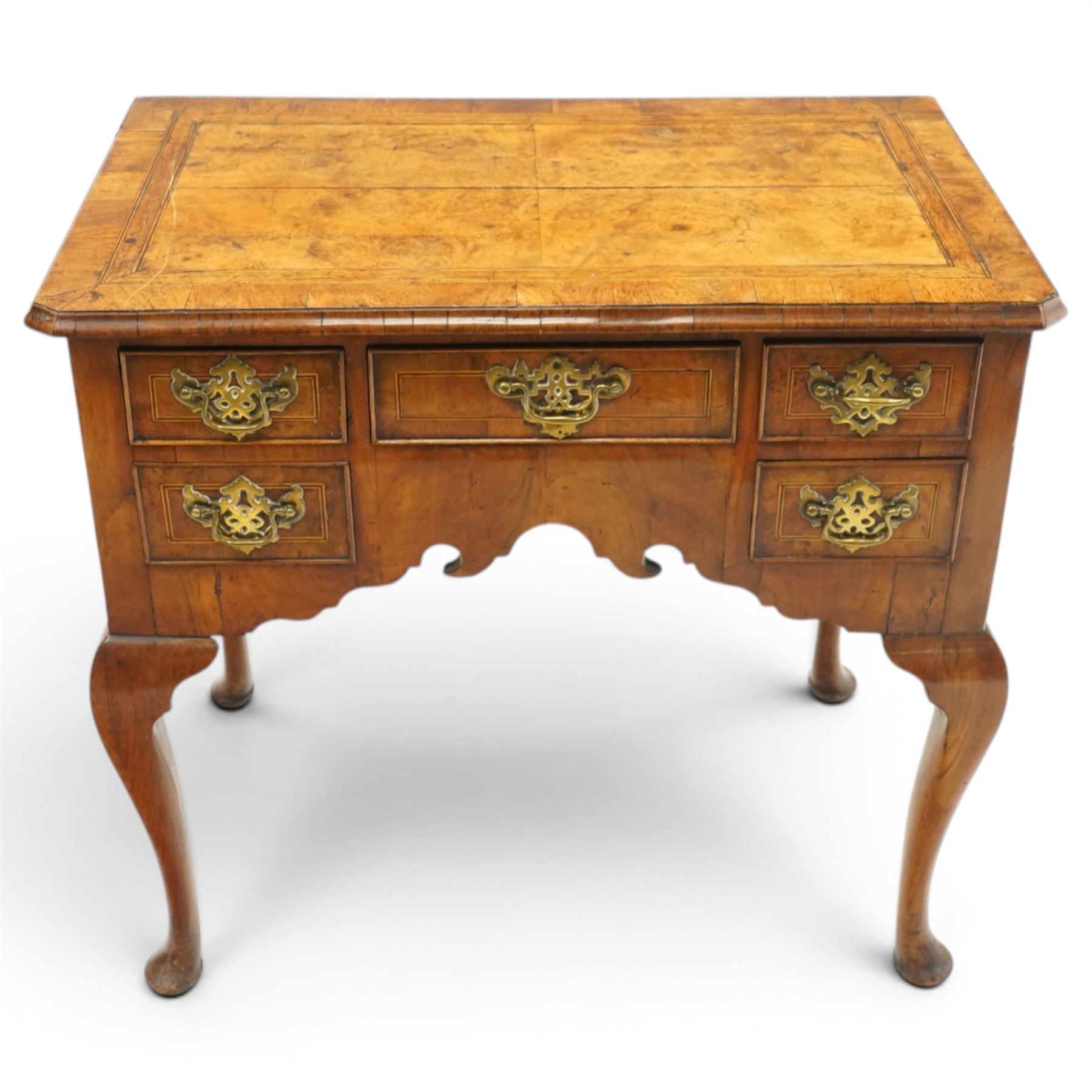 18th century figured and burr walnut lowboy, the rectangular canted top with book-matched veneer and crossbanding with moulded edge, fitted with an assortment of five cock-beaded drawers with original pierced brass handle plates, over a shaped apron, raised on cabriole supports with pad feet