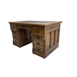 Tees & Co Montreal - early 20th century oak knee-hole desk, rectangular top with inset leather writing surface and reeded edge, fitted with two brushing slides,  central frieze drawer flanked by six short drawers and one double drawer, the twin pedestals wit panelled sides and reeded uprights