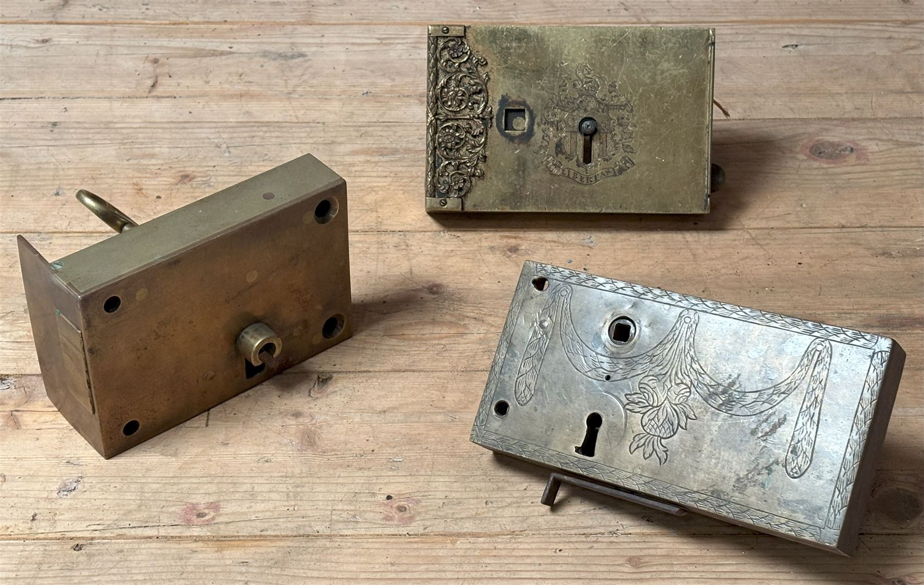 Large 19th century brass dead lock with key (16cm x 11cm) together with a gilt brass cased dead lock, the case with engraved cartouche and filigree, complete with key (18cm x 11cm) together with another engraved brass cased door lock (3)  - COLLECTION BY APPOINTMENT FROM: The White House, Thirsk Road, Easingwold, York, YO61 3NF - CALL 01723 507111 TO ARRANGE