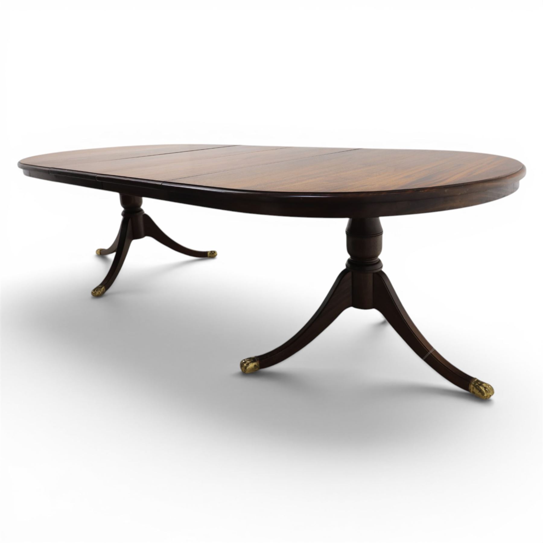 Regency design mahogany extending twin pedestal dining table with two additional leaves, raised on splayed supports terminating brass paw feet
Extends to 268cm