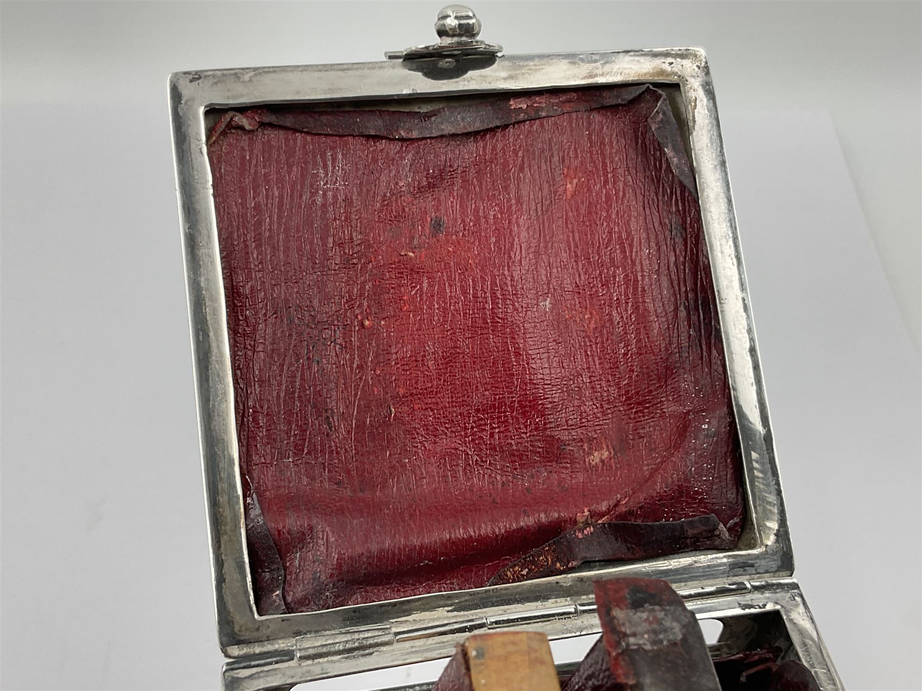 Edwardian silver mounted playing card case, hallmarked William Harrison Walter, Birmingham 1903, the sides each with a period playing card set behind a bevelled glass panel, the hinged cover with later engraving 'Presented to Norman T Crombie Esq by the officers & men of the 31st WR Detachment for services rendered 1917-1918', with red leather lined interior, the three compartments upon a sprung base and containing two later wooden Whist markers, case H12.5cm