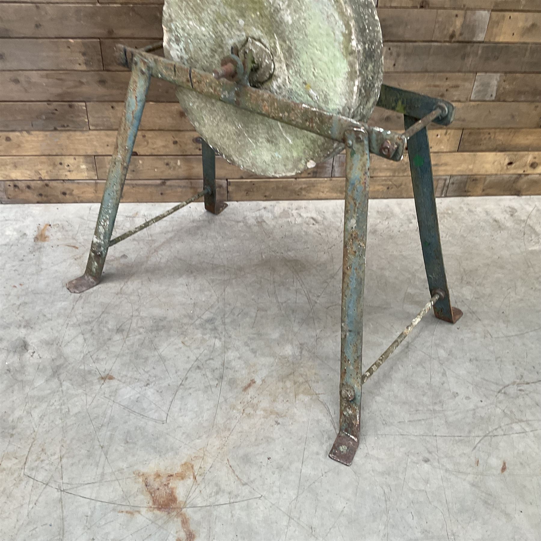 Vintage grindstone sharpening wheel mounted on metal stand, and a cast iron water pump