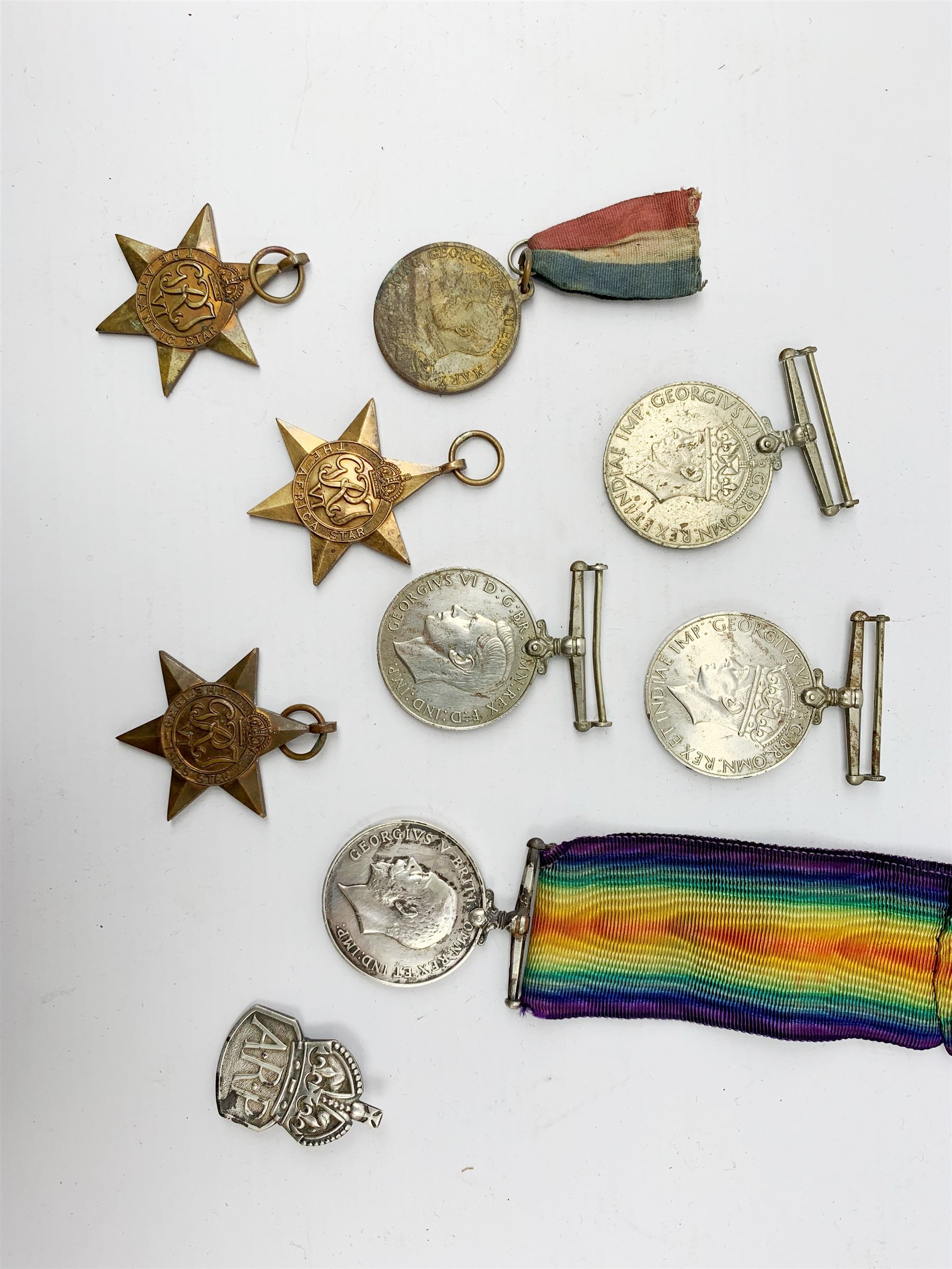 WWI British War medal awarded to 1261 Dvr. T. Paylor R.A., six WWII medals including three stars, WWII souvenir matchbox sleeve, hallmarked silver ARP badge, and an album of photographs and postcards of WWII interest, including Hitler, Montgomery, Churchill, action shots, aircraft, etc. 