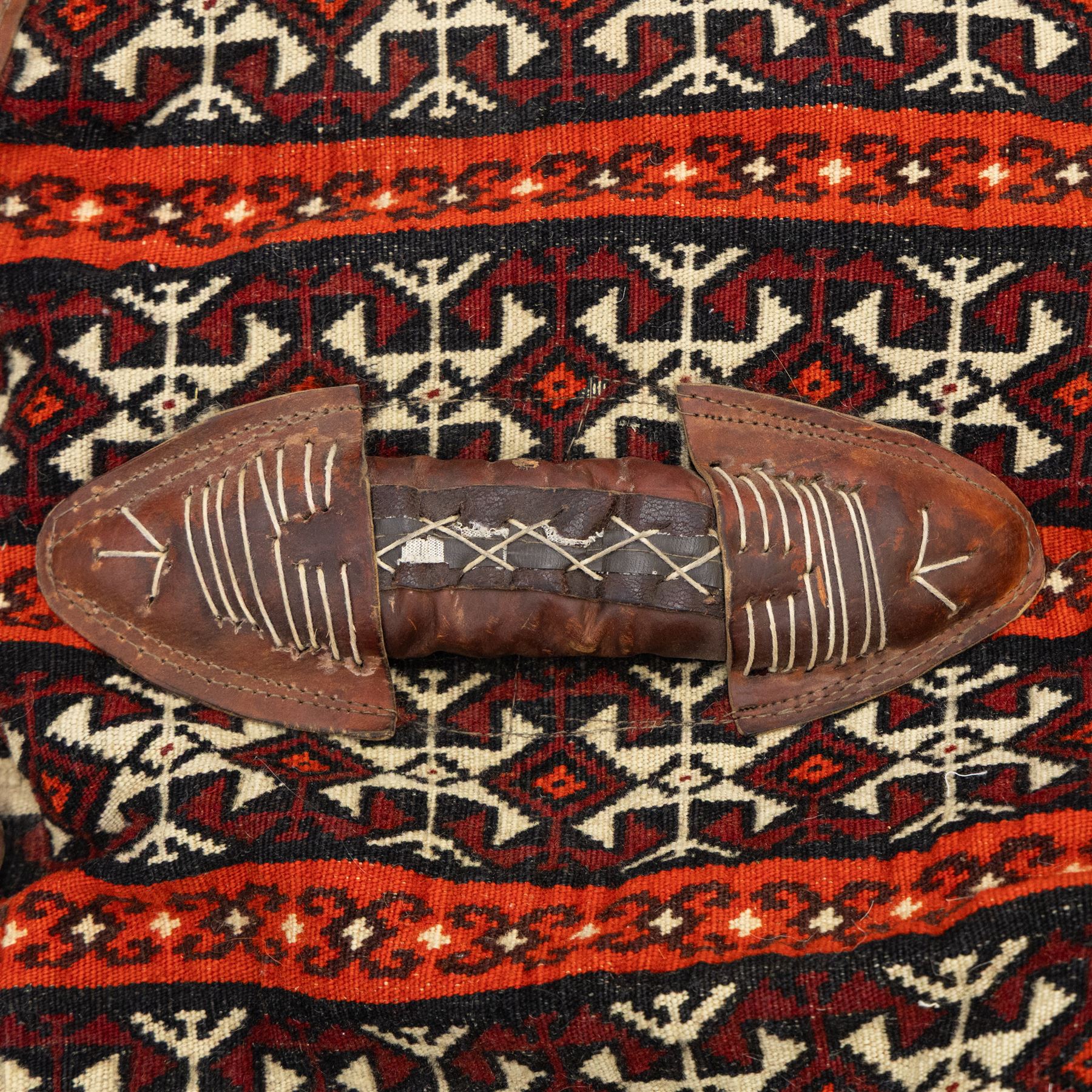 South West Persian Qashqai bag, woven body decorated with bands of geometric motifs in red, ivory and dark tones, with leather fittings and straps, underside with flatweave stripped bands 