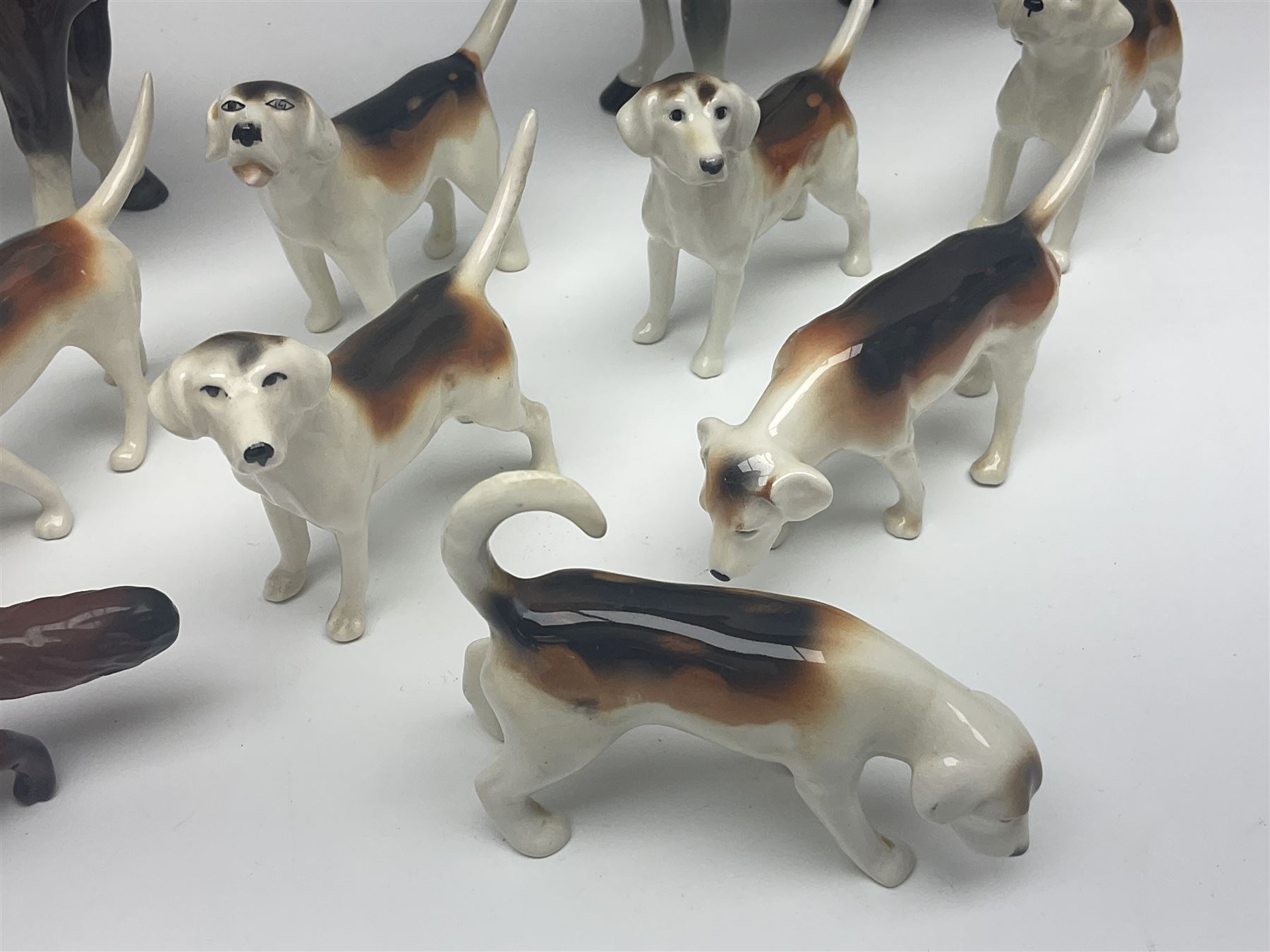 Beswick hunting group, comprising huntswoman on grey horse no 1730, huntsman on brown horse no 1501, fox figure no 1440 and eight fox hounds, all with printed marks beneath (11)