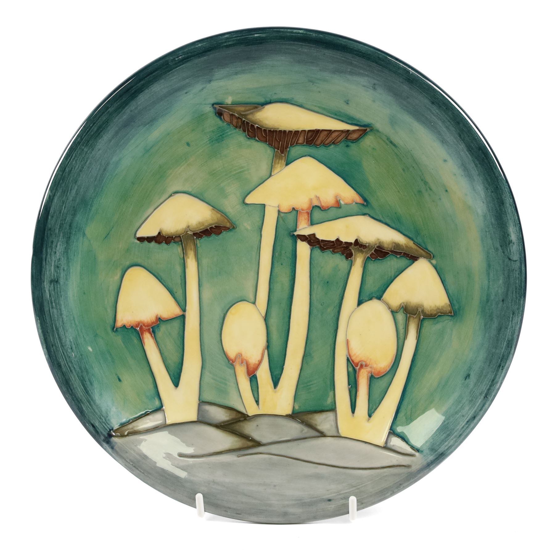 Moorcroft Fairy Ring plate, 1990, decorated with mushrooms upon a green ground, with painted and impressed marks beneath, D26cm