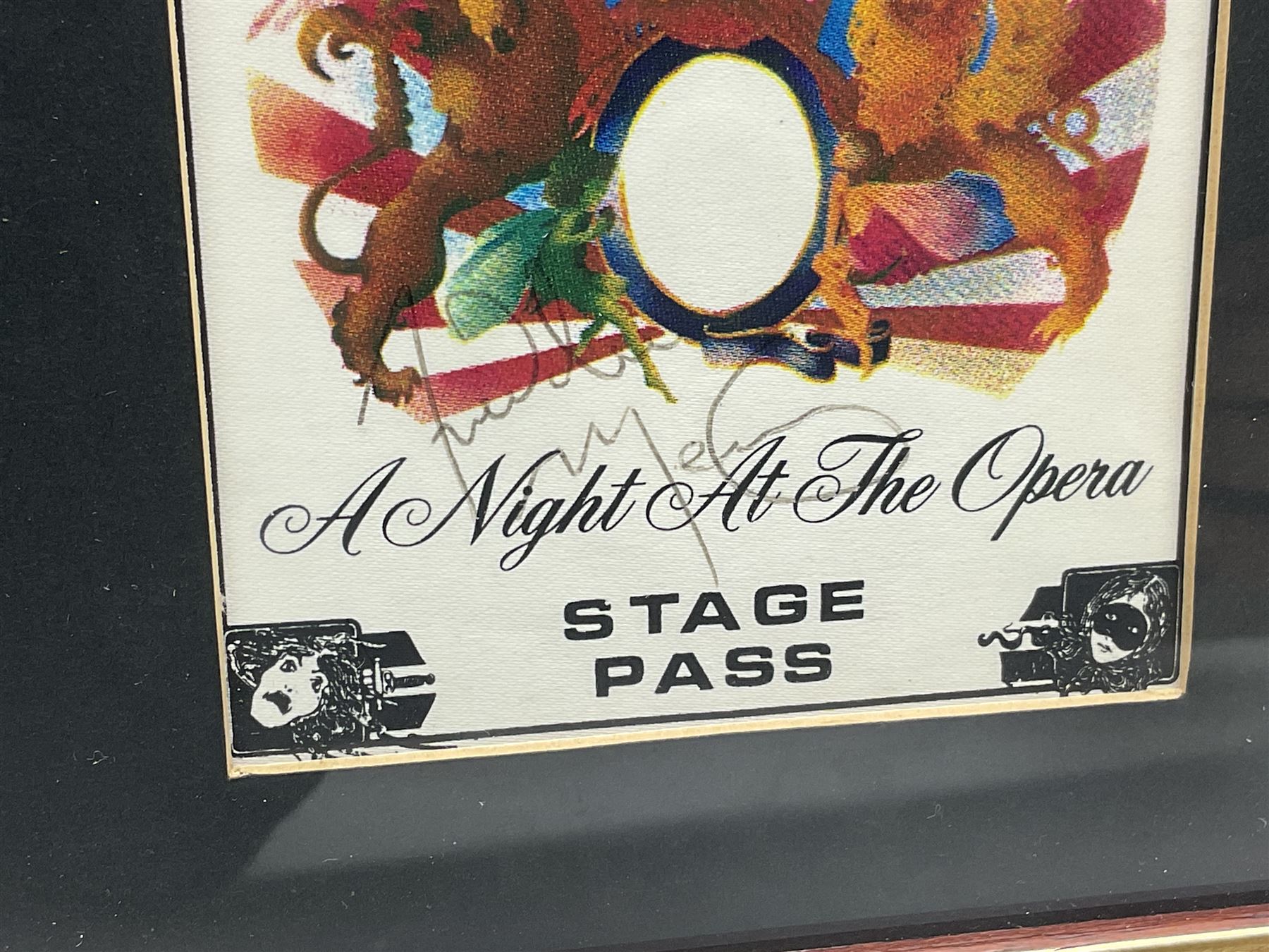 Queen - A Night At The Opera; fabric Stage Pass signed by all four members Freddie Mercury, Brian May, Roger Taylor and John Deacon 14 x 9.5cm; mounted in a modern frame with print of the band during a performance