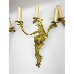 Set of three 20th century gilt metal wall sconces, each with three foliate scrolling branches rising from conforming backplates, H33cm W29cm