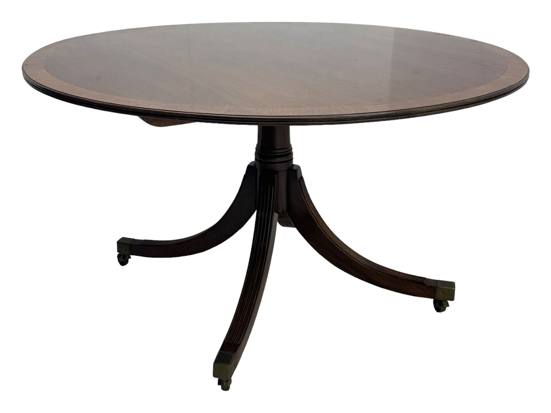 Early 20th century Regency design mahogany tilt-top table, circular top with edge banding, supported by a central turned pedestal with four reeded sabre supports terminating in castors; six chairs with pink upholstered drop in seats (7)