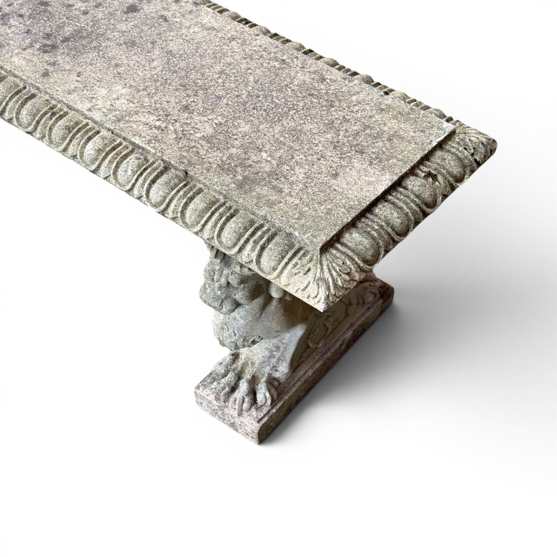 Ornate weathered cast stone rectangular garden bench, raised on winged griffin supports, square plinth bases