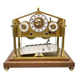 Mid 20th century 'Congreve' rolling ball clock, sloped arch and pierced brass movement, the central Arabic minute chapter ring flanked by hour and seconds dials, twin train driven eight day movement, raised on mahogany plinth with turned brass feet, under acrylic cover