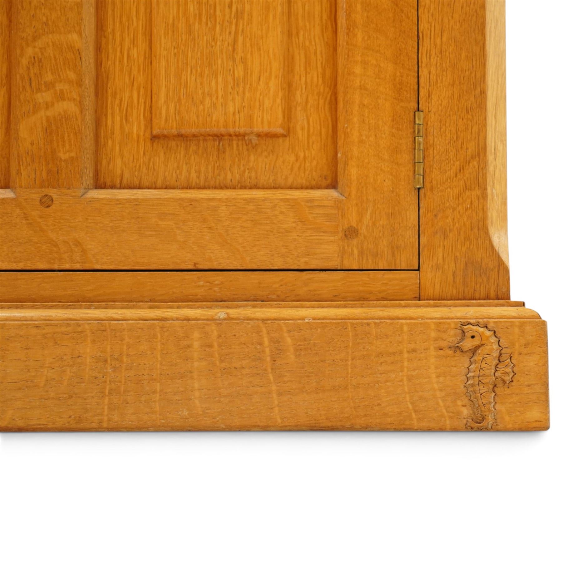 Seahorseman by Shaw & Riley - bespoke large Yorkshire oak corner sideboard or media unit, of L-shape form, with three cupboard doors, a fall front drawer over a regular drawer, a lift up panel for a record player, multiple apertures for wires, raised on a plinth base, with signature Seahorse carving from the workshop of A. Shaw & Riley Ltd, Hessay