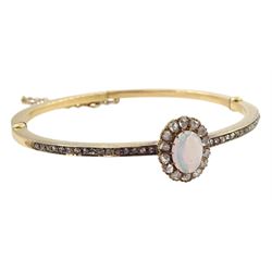 Early 20th century gold opal and diamond hinged bangle, the central opal and rose cut diamond cluster, with channel set rose cut diamonds set either side
