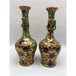 Pair of early 19th century Miles Mason vases, the baluster bodies with tall slender necks supporting twin stylised trunk handles with rings, decorated with Chinese dragons, butterflies, and blossoming flowers against a gilt ground, with spurious Chinese marks beneath in iron red, H27.5cm