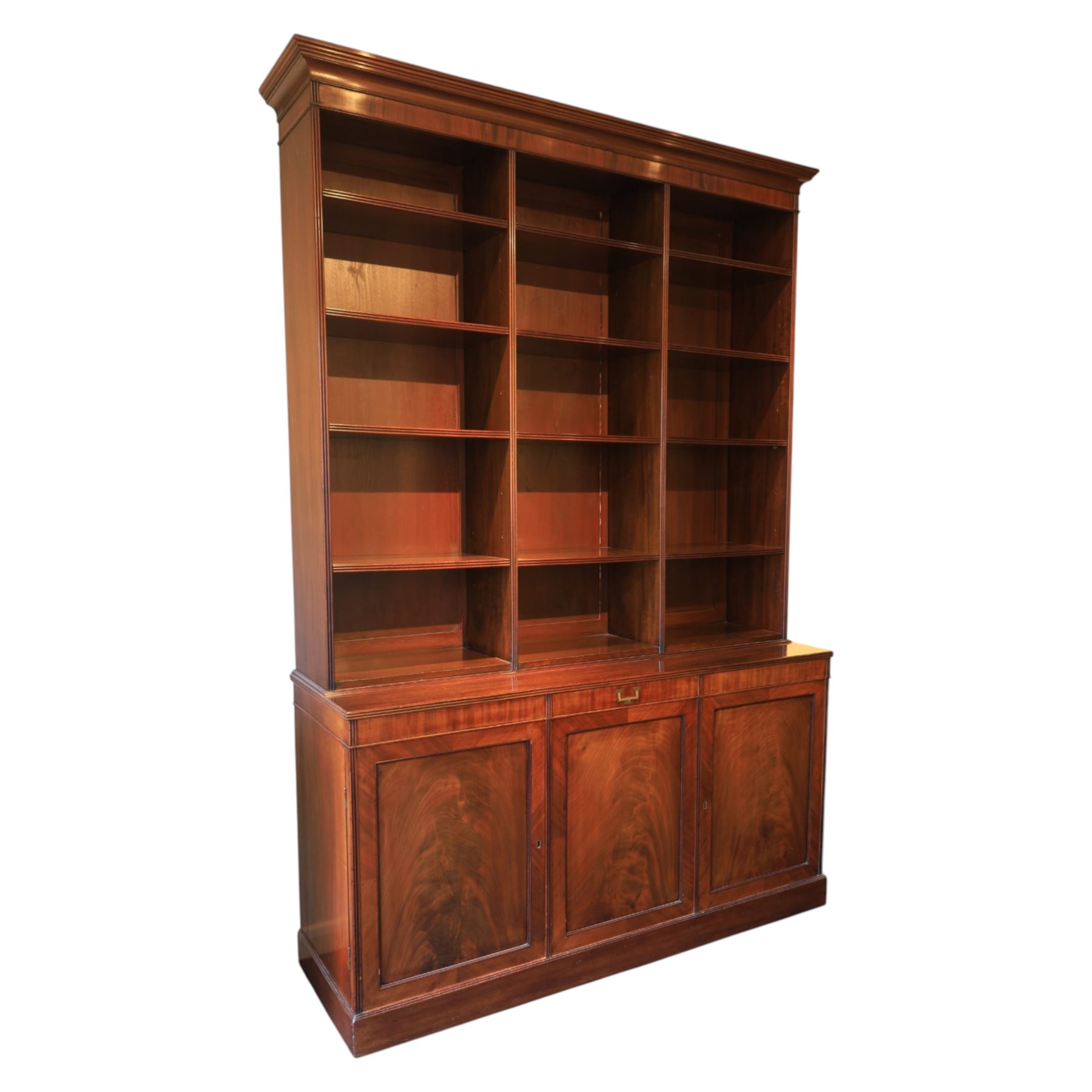 Early 20th century mahogany open bookcase, with reeded upright divisions and adjustable shelves, over a cupboard base fitted with three frieze drawers and three panelled doors, on plinth base