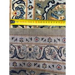 Central Persian Kashan hand-knotted carpet, ivory field with scrolling vines, palmettes, and rosettes around a cusped medallion with pendants and spandrels within a blue ground border of palmettes and flowerheads, 388cm x 300cm