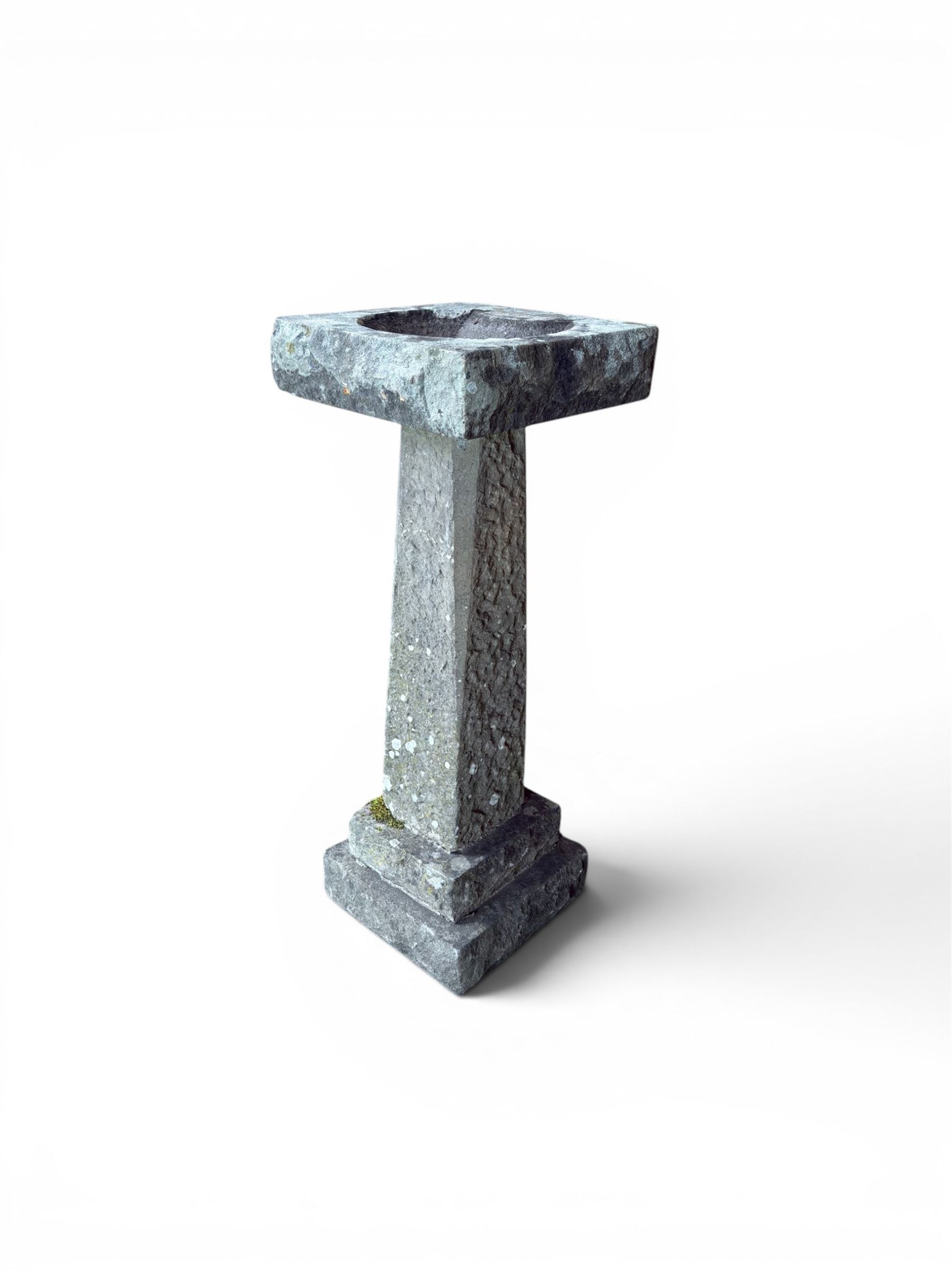 19th century weathered sandstone birdbath, formed in four sections, square top with carved shell bath, raised on tapering column with stepped base