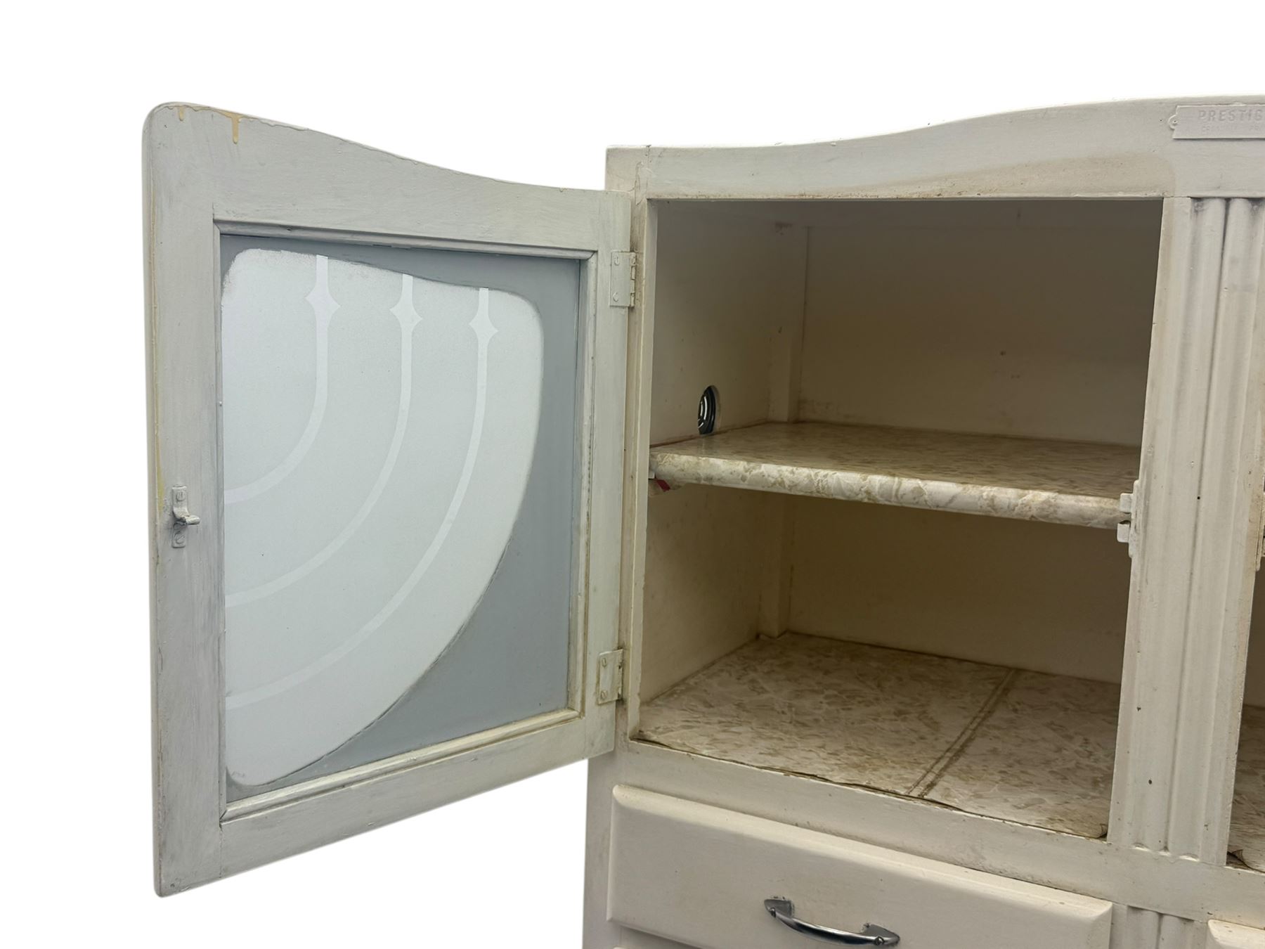 Mid-20th century painted kitchen cabinet, moulded top above a pair of glazed cupboard doors with stylised arrow motif panels, over two drawers and a fall-front cupboard, the lower section with twin cupboard doors