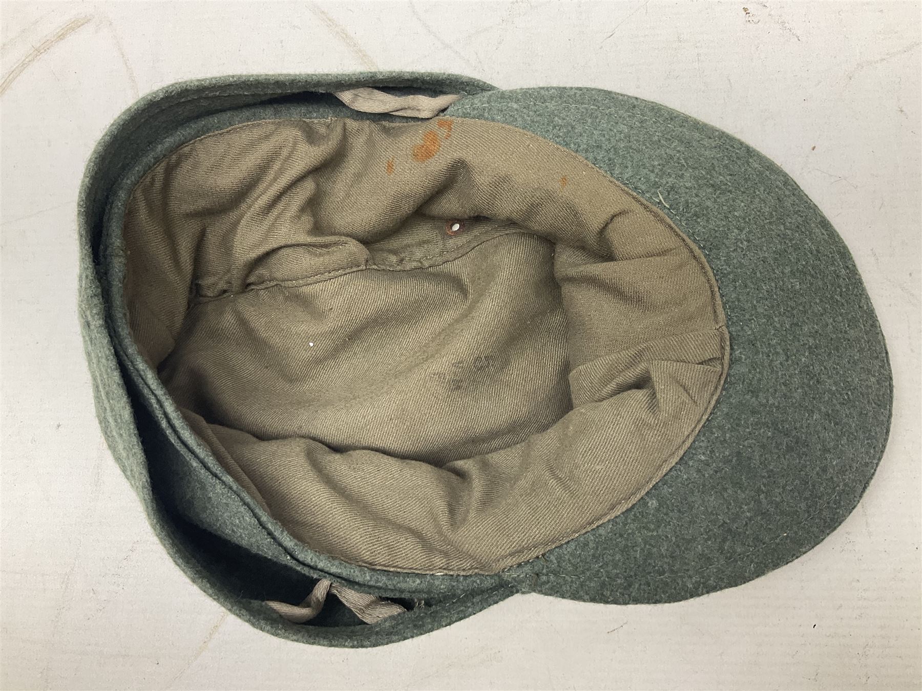 WW2 German Army M43 field cap with triangular cloth eagle and roundel badge and metal edelweiss badge for mountain troops; faintly stamped '5 VMF(?)'