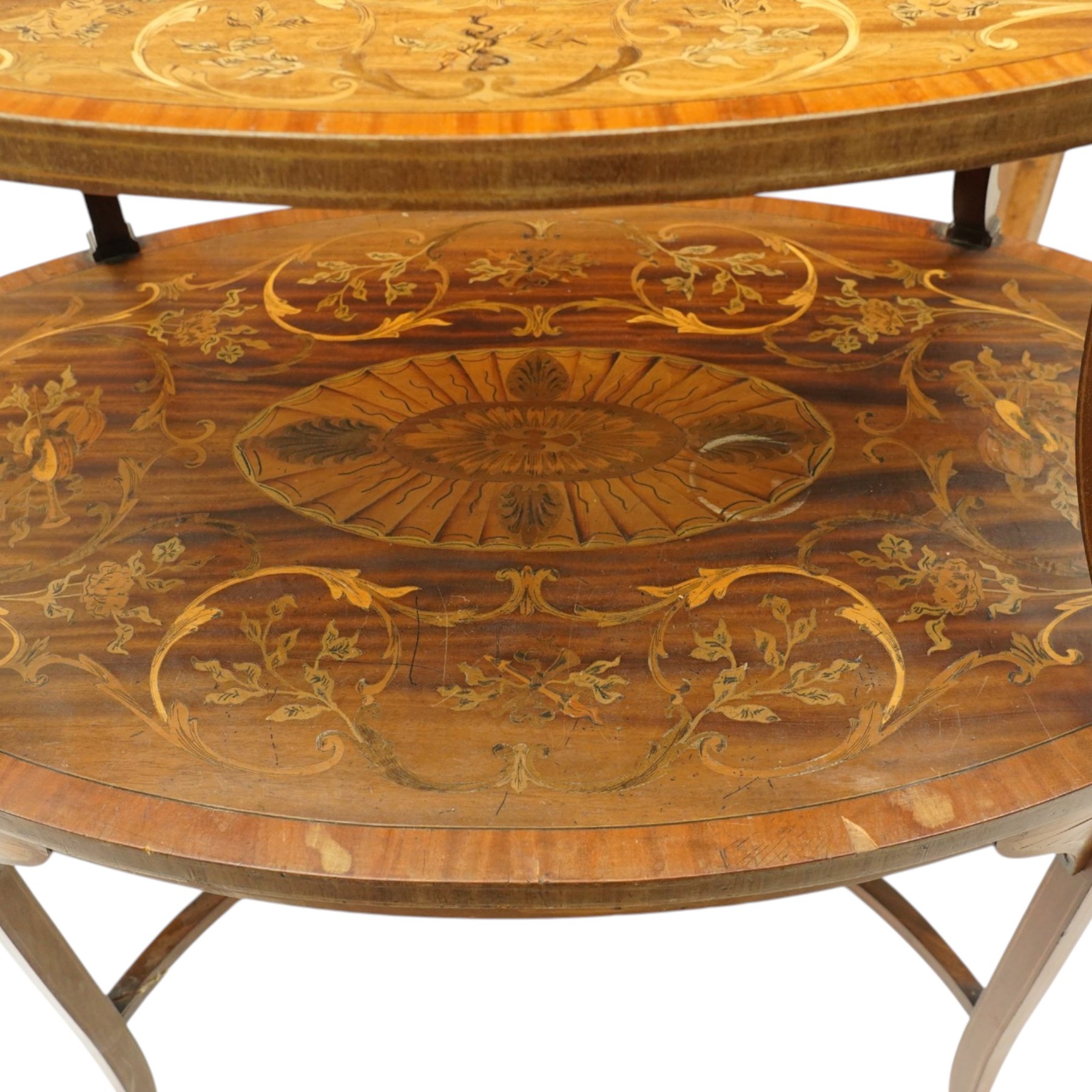 Edwardian Sheraton Revival inlaid mahogany and satinwood marquetry oval two-tier étagère occasional table, the oval top with removable glazed tray with brass handles, over an ornately inlaid top with central patera motif and trailing foliate scrolls, the splayed uprights inlaid with bellflowers, over a matched inlay under-tier, raised on splayed supports united by curved X-stretcher,  retailed by David Hick Interiors, Jersey