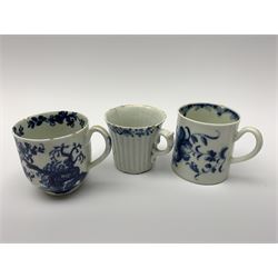 Three 18th century Worcester coffee cups, the first example of reeded form with lobed feet and scrolling handle, circa 1754, with workman's mark beneath, H5cm, the second example decorated in the Prunus root pattern, H6cm, and the third example decorated in the Mansfield pattern, with crescent mark beneath, H6cm 