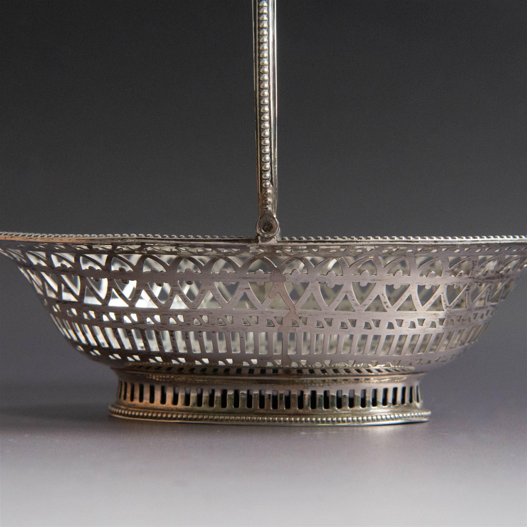 George III silver bon bon basket, of oval form with bead rim and swing handle, the sides with pierced latticework decoration, hallmarked Hester Bateman, London 1785, handle H14cm