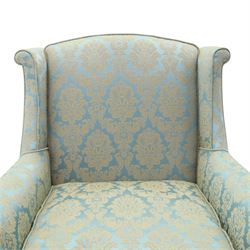 Georgian design carved mahogany framed wingback armchair, high wingback over sprung seat and loose cushion with rolled arms, upholstered in cyan ground gilt foliate damask fabric, on shell-carved cabriole supports with pad feet