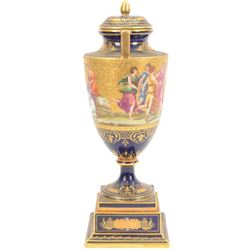 Late 19th century Vienna twin handled urn and cover decorated with classical figures on a textured gilt ground,  upon a square stepped cobalt blue pedestal with gilt detailing, H36cm