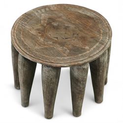 African Nupe carved tribal stool, the rounded top with repeating incised decoration and rope-edge border, supported by ten tapered legs D37cm