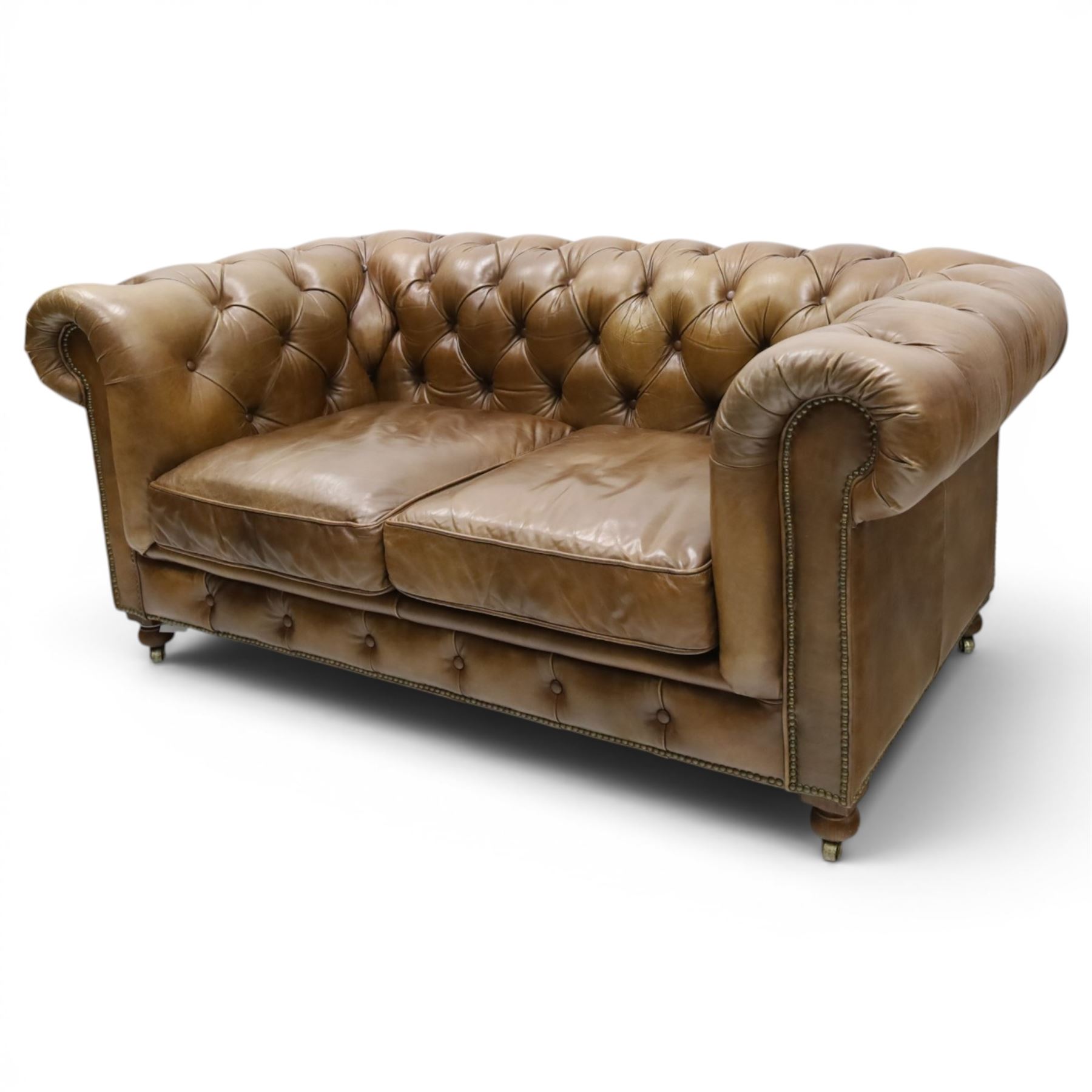Timothy Oulton for HALO - Two seater brown leather chesterfield sofa, with button back and arms, with two loose cushions, raised on a dark stained supports terminating in castors 
