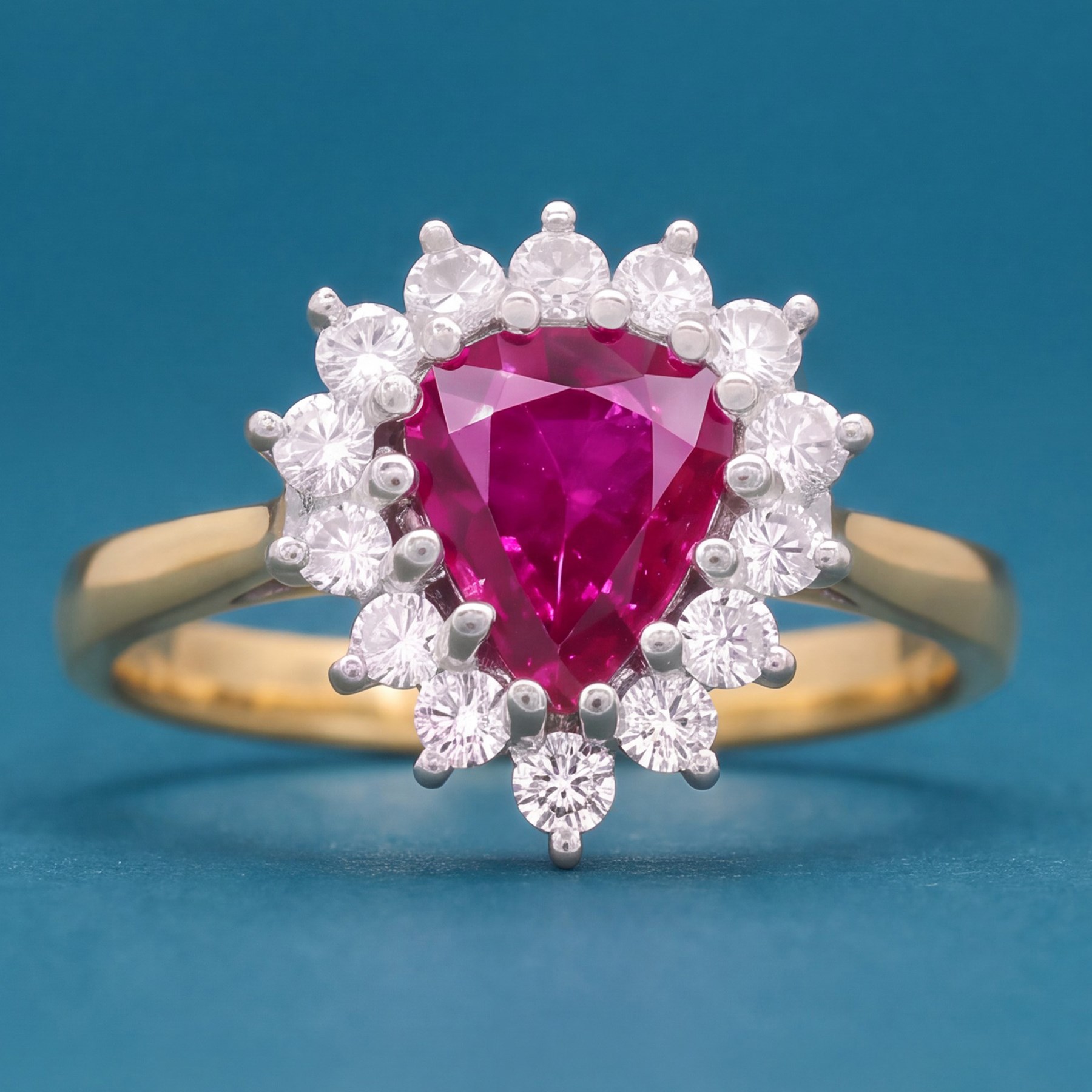 18ct gold ruby and diamond cluster ring, single pear cut ruby of approx 1.05 carat, surrounded by fourteen round brilliant cut diamonds, Birmingham 1988, total diamond weight approx 0.40 carat