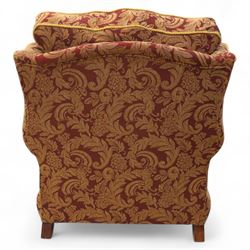Duresta – pair of armchairs, upholstered in red and gold damask fabric with piped edges, scroll arms and loose feather-filled cushions, raised on turned wooden feet with brass castors